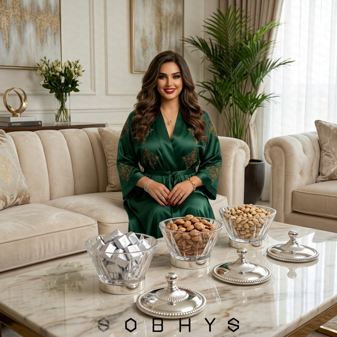 Woman in a green robe sitting in a stylish living room with decorative items on the table. Sobhys Luxury Acrylic Serving Bowl – Silver-Tone Base Detail and Rope-Edge Border
