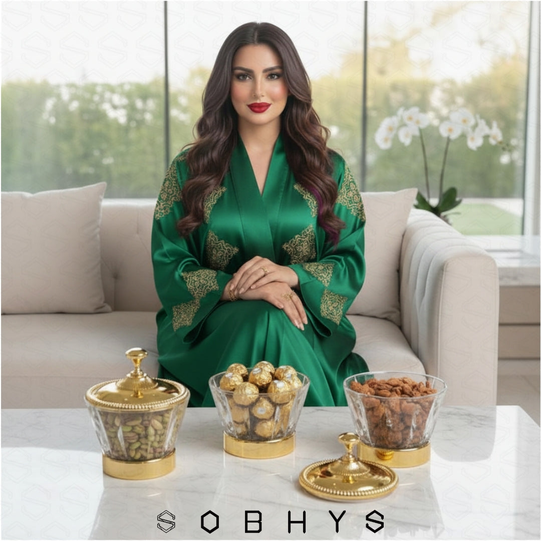 Woman in a green dress sitting on a couch with decorative items on a table, featuring the brand 'SOBHYS'.
