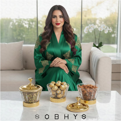 Woman in a green dress sitting on a couch with decorative items on a table, featuring the brand 'SOBHYS'.